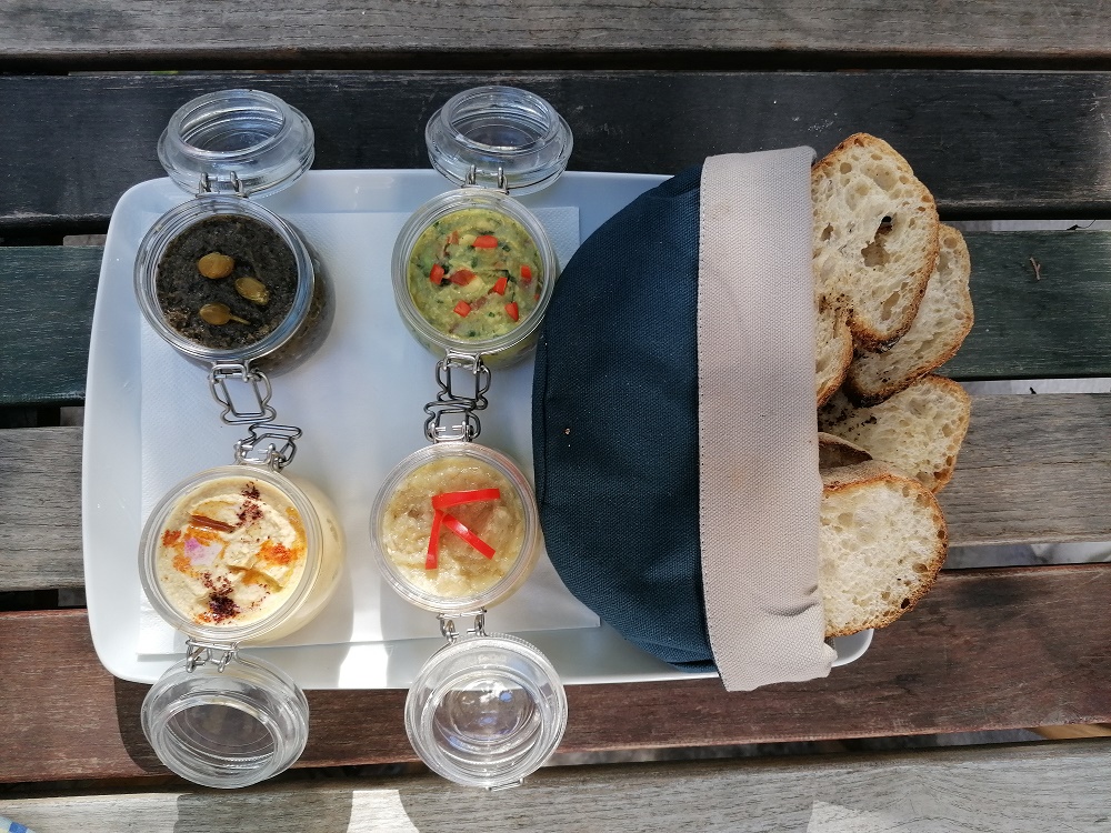 Un basarabean din Chișinău stabilit în București oferă clienților pub-ului său salată de humus, preparată cu năut din Piața Obor, după sfaturile unui bucătar american