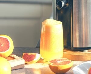 Fresh orange juice in a glass close up on kitchen table.