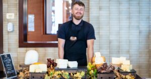 Fermierul George Cățean, inițiator al comunității „România cu Bun Gust”, în fața unui mese cu brânzeturi