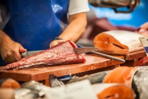 Un măcelar taie o bucată de ton